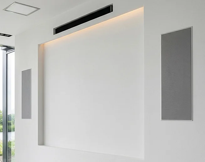 Naadloos afgewerkte en modern gestucte tv-wand met geïntegreerde opbergruimte.