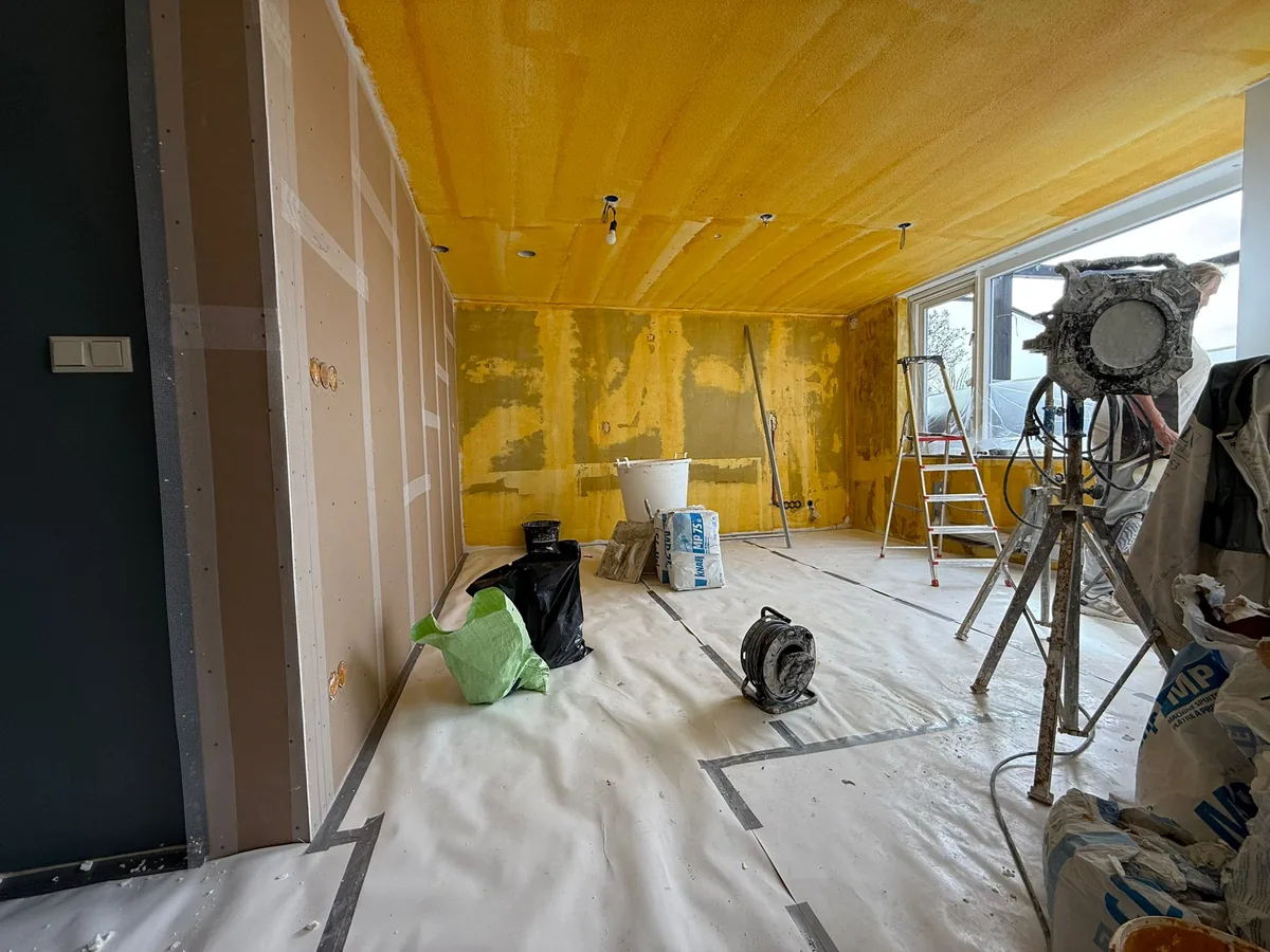 Gele hechtprimer op de wanden voor het stucwerk in de woning aan de Prunuskade