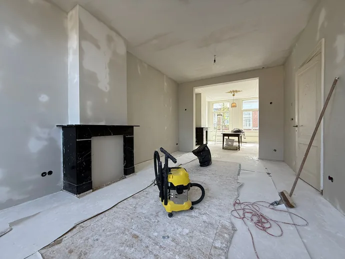 Woonkamer aan de Piet Heinstraat in Den Haag voor het stucwerk, met oude gele wanden